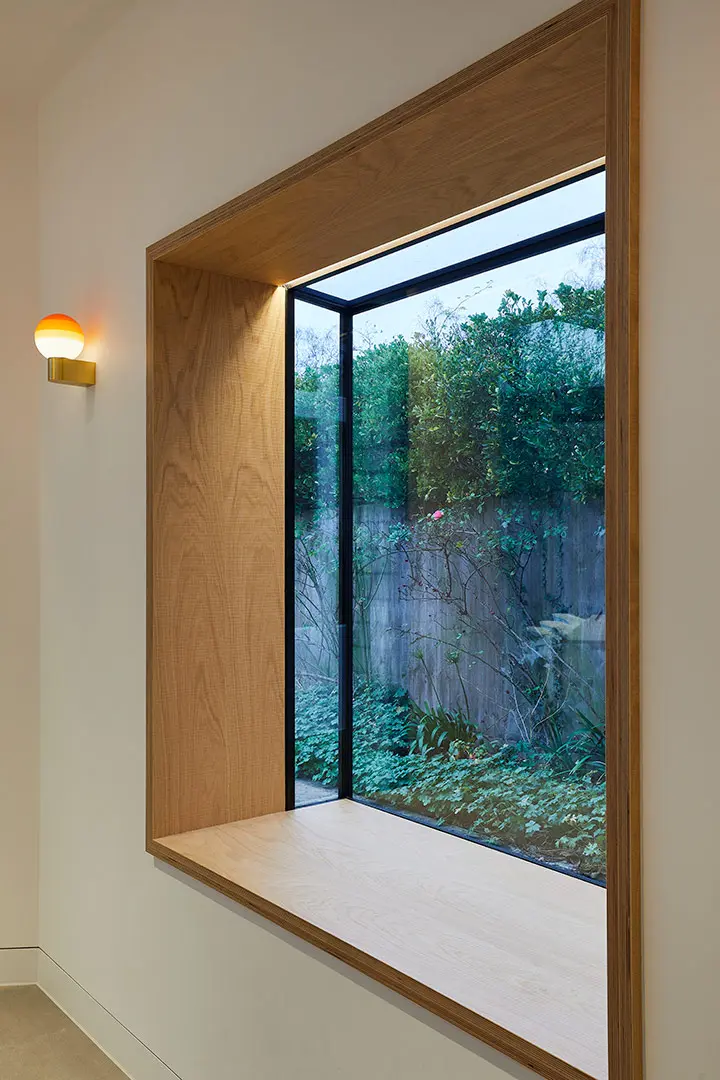 Deep oak-lined window seat framing the garden